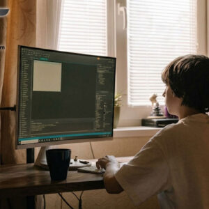 Young person coding on PC